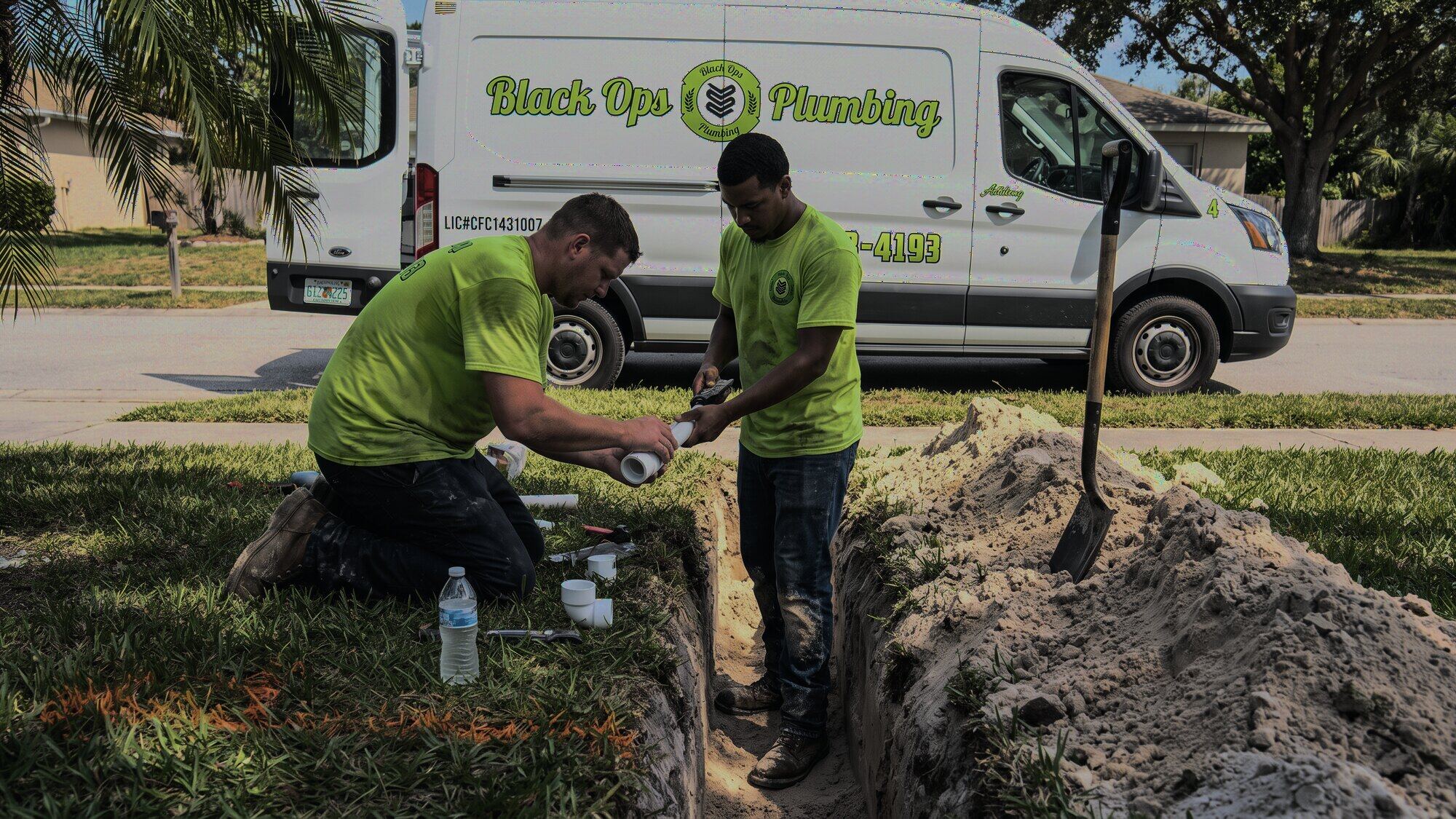 Black Ops crew fitting a new line in a trench, van behind them